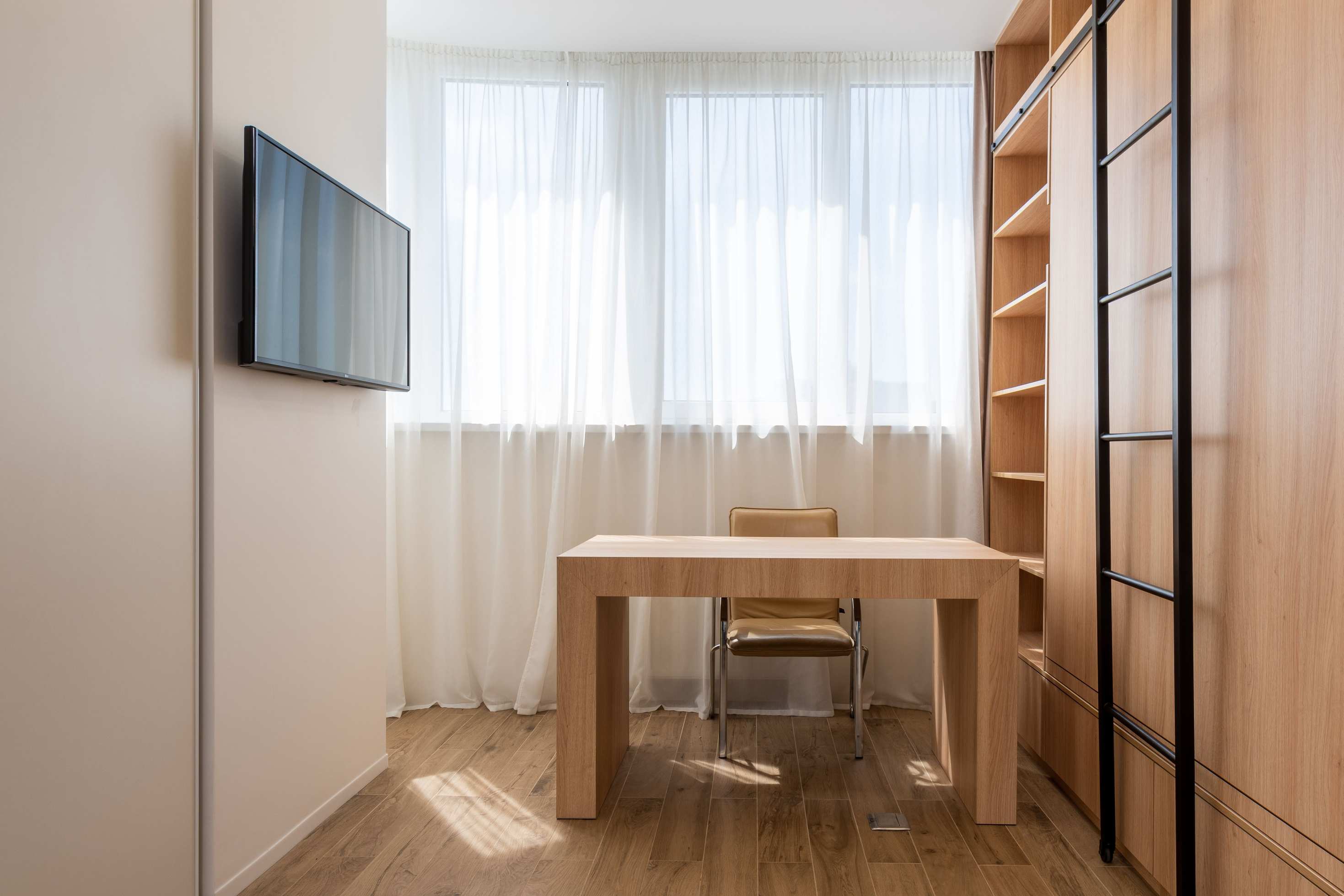 Weit aufgenommenes Büro mit Regalen und Schreibtisch, study room